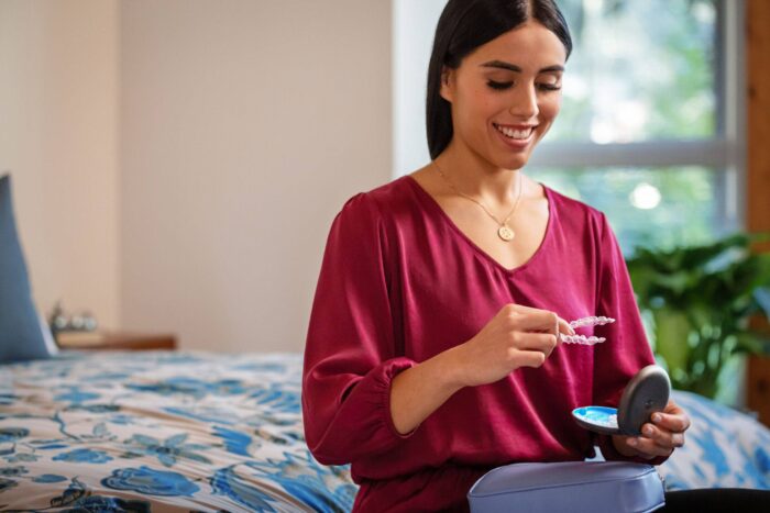 Women holding a pair of Invisalign braces